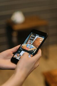 Hands holding smartphone taking a photo of a sale display in a store.